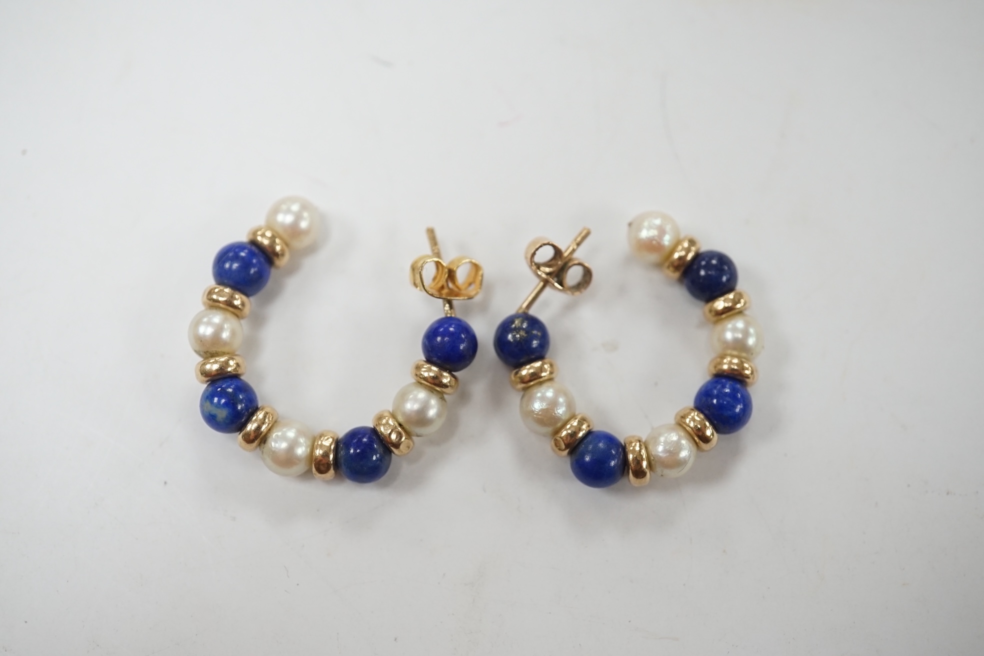 A modern pair of yellow metal lapis lazuli and and cultured pearl cluster set half hoop earrings, 25mm. Condition - fair to good